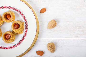 Oriental Sweets - kunafa in a plate on white wood background
