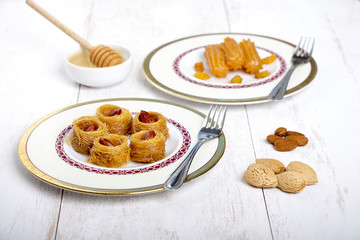 Oriental Sweets - kunafa in a plate on white wood background