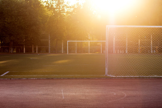 View of the football stadium at sunset. Rays of sunlight. Football lawn, football goal. Sport. The background
