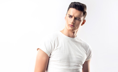 Obraz premium Fashion portrait of a handsome serious man with trendy hairstyle in a white shirt