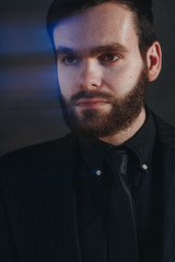 handsome unshaved man on black background with special effects