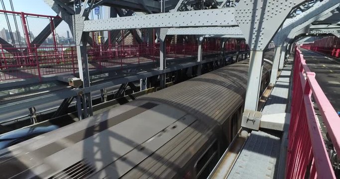 A pedestrian's view of the subway J-train passing over the Williamsburg Bridge over the East River between Manhattan and Brooklyn.  	