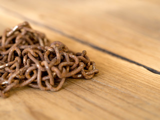 Rusty old steel chain put on a wooden table