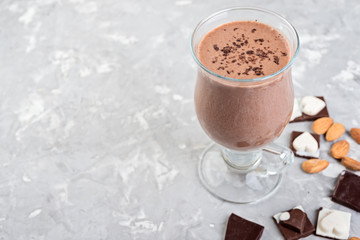 Chocolate smoothie with banana and nuts  on a grey stone  table.