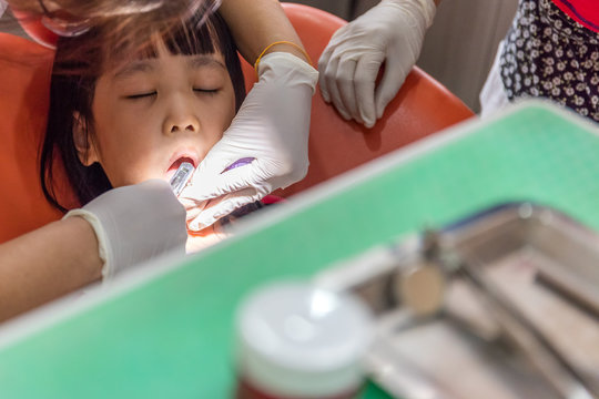 Asian Chinese little girl lying down for tooth extraction