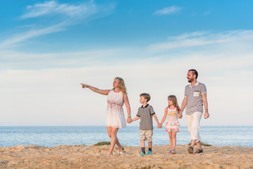 Family walking together alongside the sea