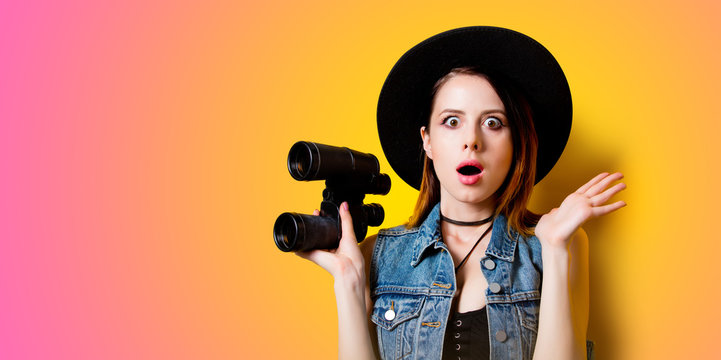 Portrait of young adult woman in hat with binocular