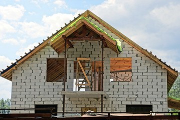 строительство белого кирпичного дома на фоне неба и облаков