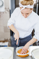 Woman in white uniform prepares food