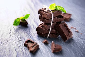 Tied chocolate pieces with mint on table