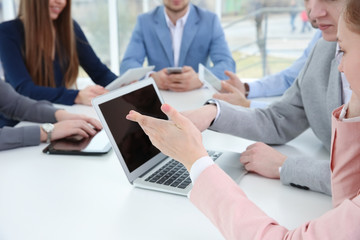 Fototapeta premium Team work concept. People sitting at table in office and using digital devices