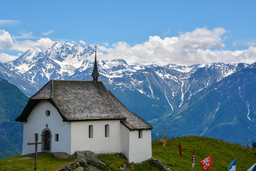 Fototapeta na wymiar An old white chapel with the mountains in the background