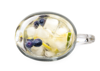 Tasty lemonade with slices of citrus fruits and blueberries on white background