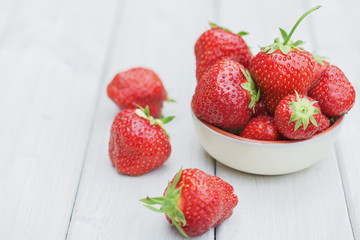 Bowl filled with strawberries on a wooden table