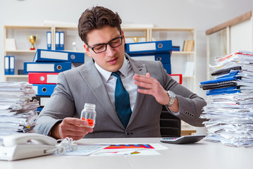 Businessman taking pills to cope with stress