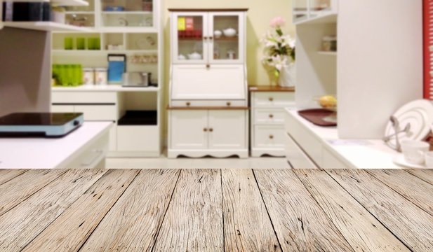 Empty wooden table floor with blur image of modern kitchen room interior , product montage display and design.