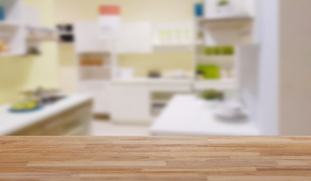 Empty wooden table floor with blur image of modern kitchen room interior , product montage display and design.