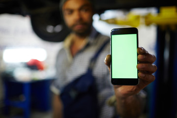 Smartphone with empty touchscreen held by technician