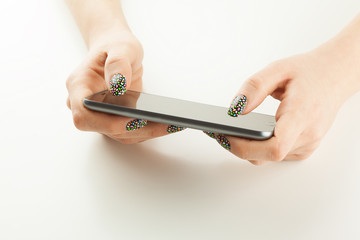 Woman's hand holding black phone isolated on white