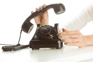 Woman's fingers dialing a vintage rotary dial telephone - obrazy, fototapety, plakaty