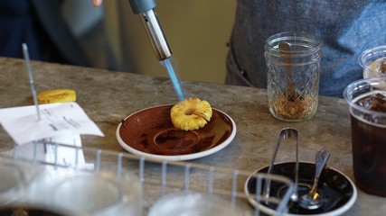 chef is cooking pineapple slices with gas burner.