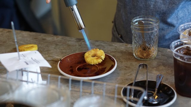 chef is cooking pineapple slices with gas burner.