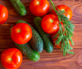Summer vegetables on a wooden background. Cucumbers, tomatoes on the table