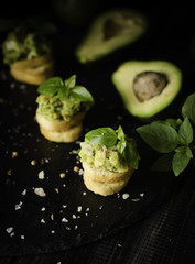Toasts with pasta from avakado or guacamole and spices on wooden table with fruits, selective focus, concept