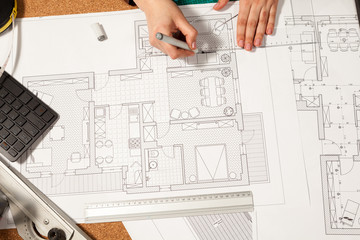 Close up of hands working on blueprints on table. Construction and architecture. Project and design