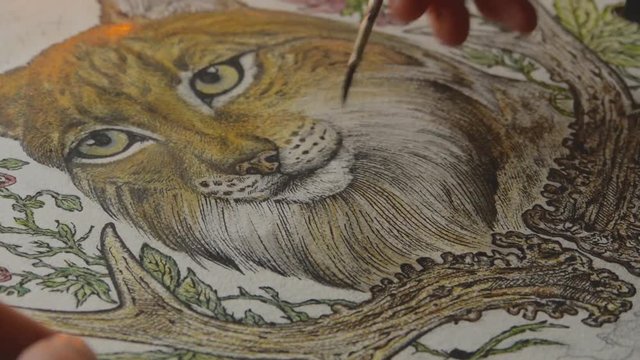 female artist painting a picture of a lynx with a brush on piece of paper