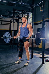 Obraz na płótnie Canvas Bodybuilder doing biceps workout with barbell.