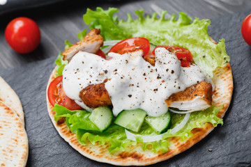 Preparing mexican fajita wrap with chicken meat and vegetables
