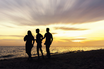 happy family watching the sunset on the beach