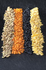 Grüne, rote, schwarze und gelbe Linsen in Reihe