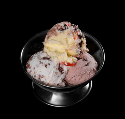 Fruit and chocolate ice cream in metal bowl isolated on black background