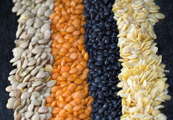 Grüne, rote, schwarze und gelbe Linsen in Reihe