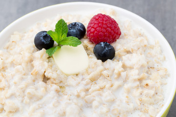 Oatmeal porridge in bowl with berries raspberries and blackberries.
