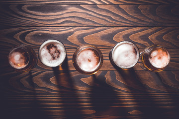 Beer glasses on an old dark wooden table. Top view