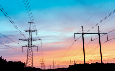 Electricity pylon in a field with blue sky.
