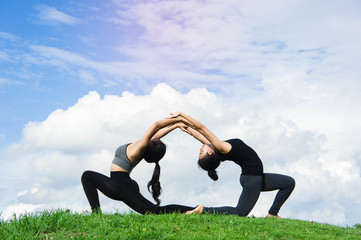 Fototapeta premium Woman practicing yoga relax in nature and blue sky background , Yoga Exercise Helps the mind to concentrate, calm and shape and healthy.