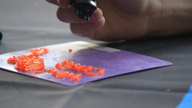 Drawing 3d pen draws with hardening photopolymer close-up. Person drawing with 3D pen that draws a liquid photopolymer that hardens under the action of the ultraphylet