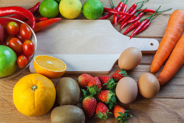 Healthy concept with mixed fruits and vegetables on wooden background