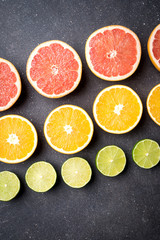 Half of citrus fruits on dark stone background 