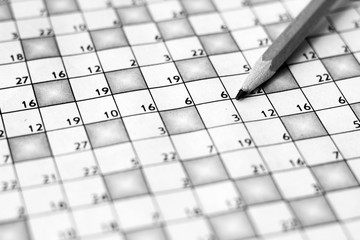 Vertical close up of a sharp pencil on a crossword puzzle