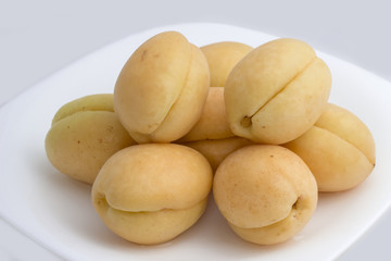 Apricots on the plate on white background