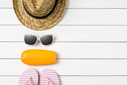 Summer Background With Straw Hat, Sunglasses, Sunscreen Bottle And Pink Flip Flops