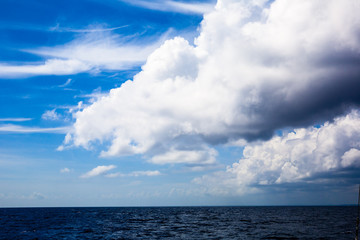 Naklejka na ściany i meble A large heavy cloud above the blue sea.