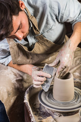 pottery, workshop, ceramics art concept - yong male sculpt some new utensils with hands, tool,...
