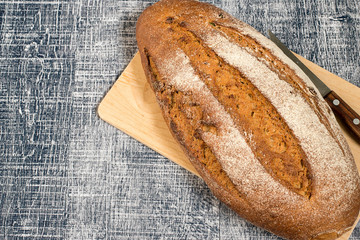 Bread.  Homemade bread from rye flour, on a kitchen cutting board on a wooden background.