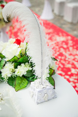 beautiful, gorgeous wedding decoration in red and white colors, flowers, feather pen